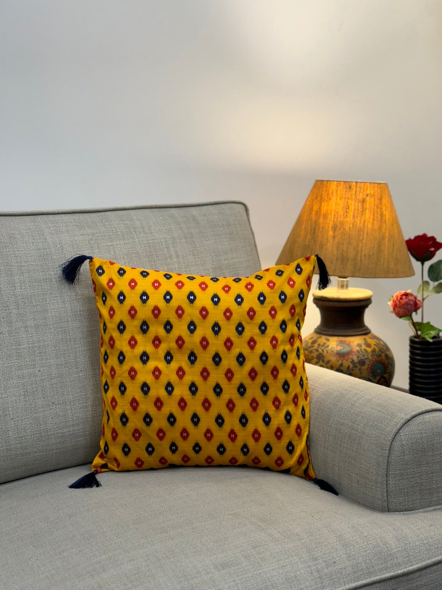 yellow patola cushion cover with black tassels