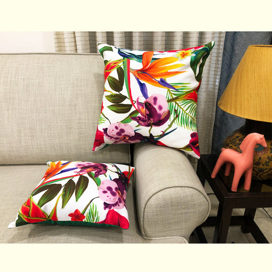 A cushion cover with a colorful floral pattern displayed on a sofa.