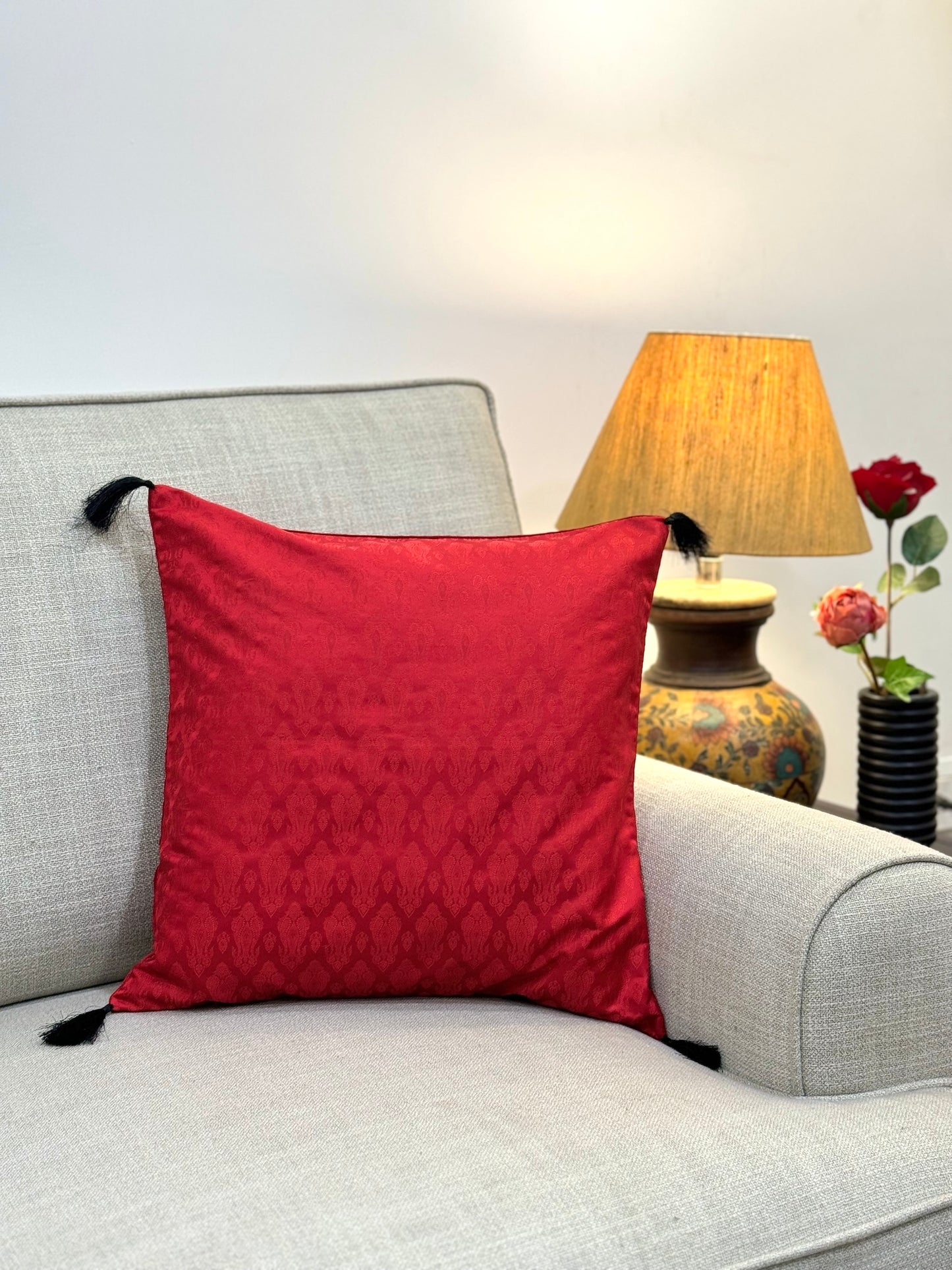 bright red cushion cover with delicate black tassels
